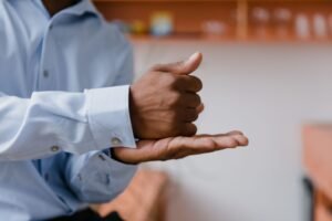 Body Language as a Sales Tool Certification - A man using sign language indoors with a focus on hand gestures and communication.