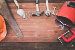 Onboarding Tools Certification - Flat lay of various workshop tools on a rustic wooden table, showcasing DIY essentials.