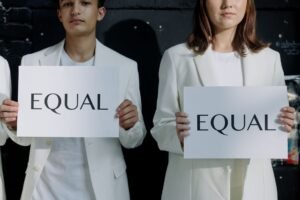Equality, Diversity & Discrimination Awareness Certification - Young individuals holding 'Equal' signs promoting equality indoors.