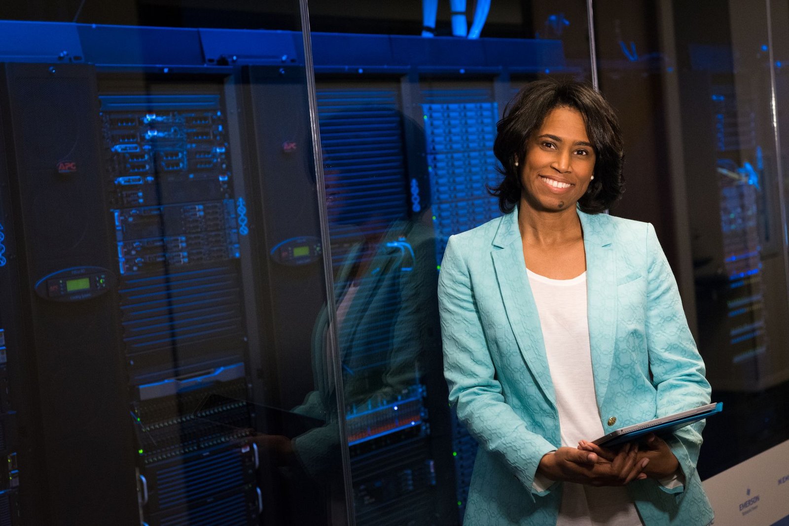 Cybersecurity for Senior Leaders - Smiling woman in data center showcasing technology expertise.