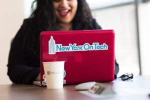 Microsoft Outlook Certificate Level 3 - Young woman working remotely with a laptop in a modern indoor office setting, showcasing tech culture.