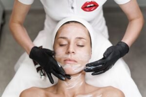Facial Treatments Certificate - Woman receiving a facial treatment at spa, with beautician applying mask in a relaxing setting.