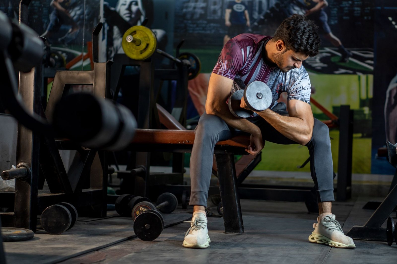 Finding Motivation to Get Fit and Stay Fit Certification - A muscular man working out in a gym, lifting a dumbbell for strength training.