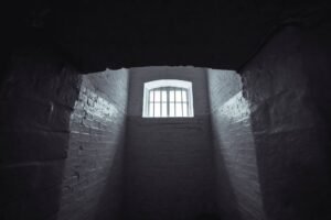 Working in Confined Spaces Certification - Moody shot of an abandoned prison cell in Hong Kong with dim lighting and shadowy walls.