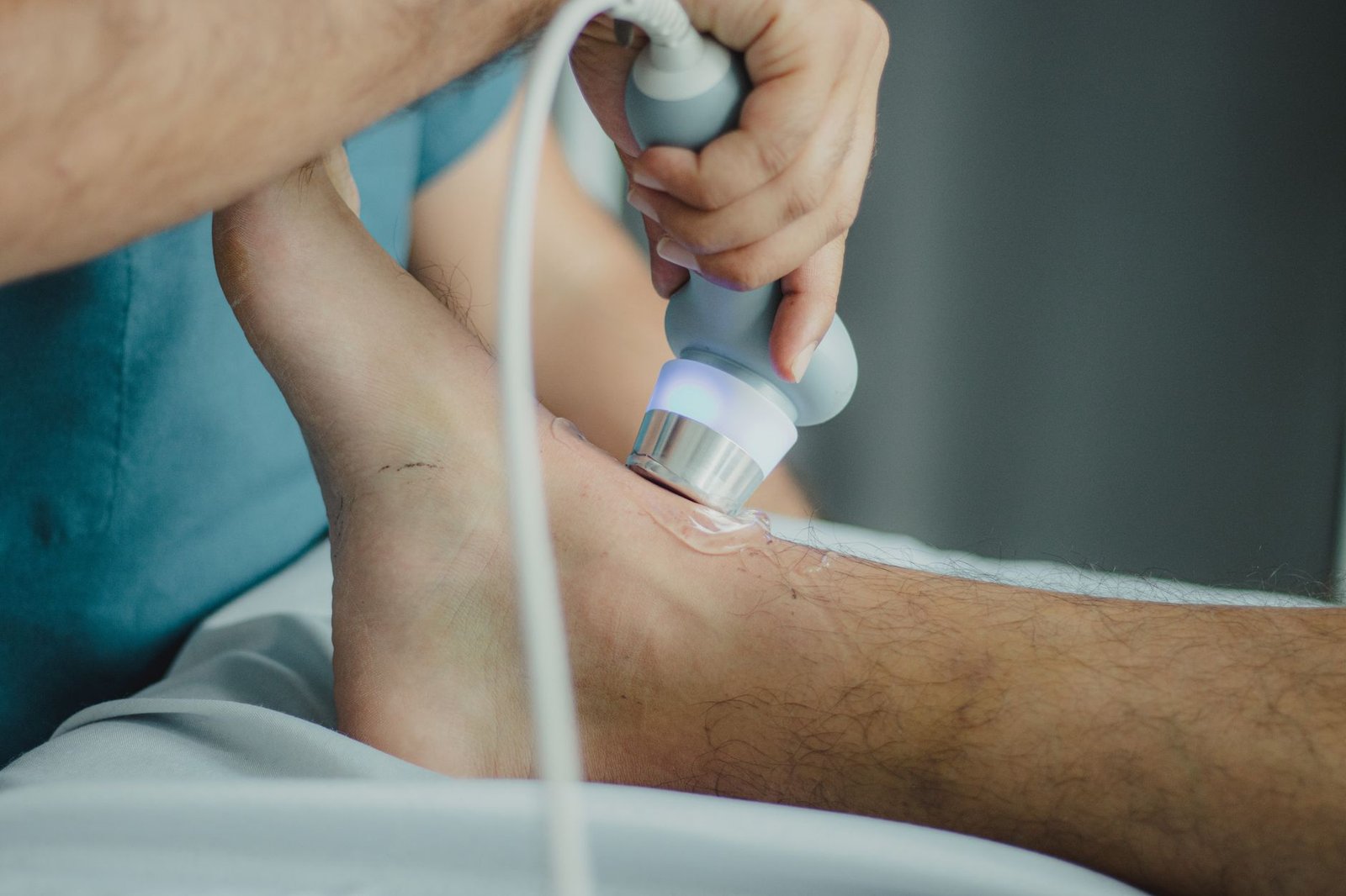 Pain Management Certification - Professional physiotherapist using ultrasound device for leg treatment.