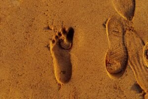 Digital Footprint - Close-up of human and shoe prints in beach sand, showcasing texture and summer vibes.