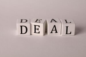 Negotiating and the Concept of the Three Ps Certification - Close-up of white cubes with black letters spelling DEAL on a plain background.