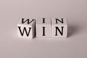 Win-Win Negotiations for Conflict Resolution Certification - White cubes with the word 'WIN' against a light background symbolizing success and achievement.
