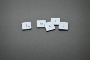 How to Write Better Emails Certification - Close-up of the word 'email' formed with letter tiles on a gray surface.
