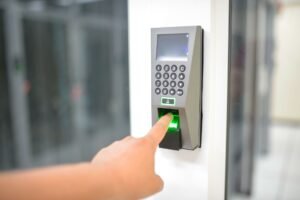 Secure Printing - A person uses a fingerprint scanner for secure entry in a business setting.