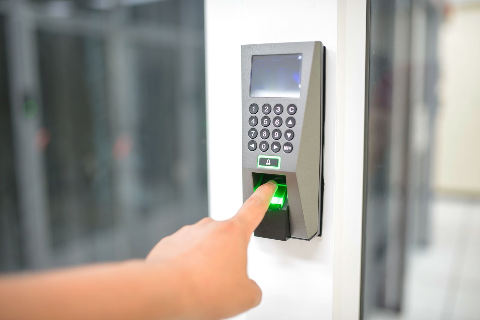 Secure Printing - A person uses a fingerprint scanner for secure entry in a business setting.