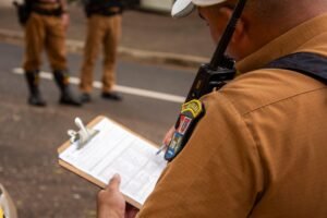 Incident Reporting - Close-up of a police officer writing on a clipboard outdoors in Londrina, Brazil.
