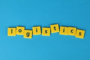 Event Management Logistics and Troubleshooting Certification - Yellow letter tiles spelling 'logistics' on a vibrant blue background, ideal for business and logistics themes.
