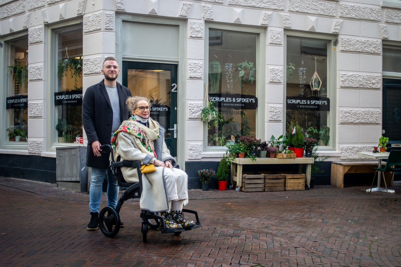 Health and Safety Basics and Essentials Certification - Elderly woman in wheelchair with companion outdoors in 's-Hertogenbosch.
