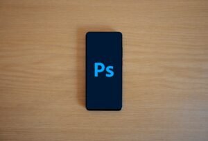 Digital Art Tools for Photoshop Certification - Top view of a smartphone showing Adobe Photoshop on a wooden surface.