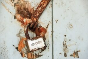 IT Security Certification - Close-up of a rusty padlock on a weathered wall, showcasing vintage charm.