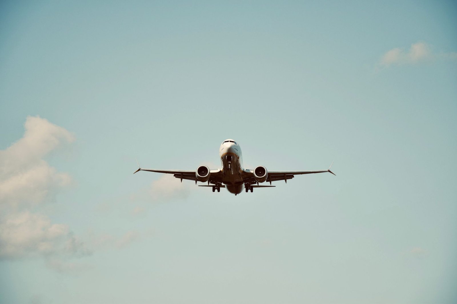 Travel and Tourism Certification Level 2 - A commercial airplane in flight against a clear blue sky, representing air travel and transportation.
