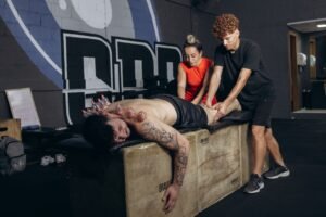 Sports Science and Therapy Certification - Athlete receives cupping therapy and massage for recovery in a gym setting.