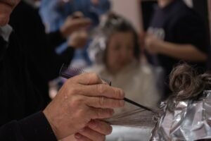Person-Centred Care Certificate - Hair salon scene with a hairdresser using foil and comb for highlights.