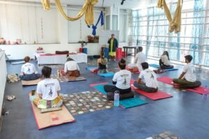 Introduction to Teaching Yoga Certificate - Group of adults attending a yoga class in a spacious, modern studio with an instructor.