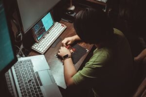 Introduction to Cloud Computing Certification - Person engaged in detailed artistic work at home office desk with technology tools.