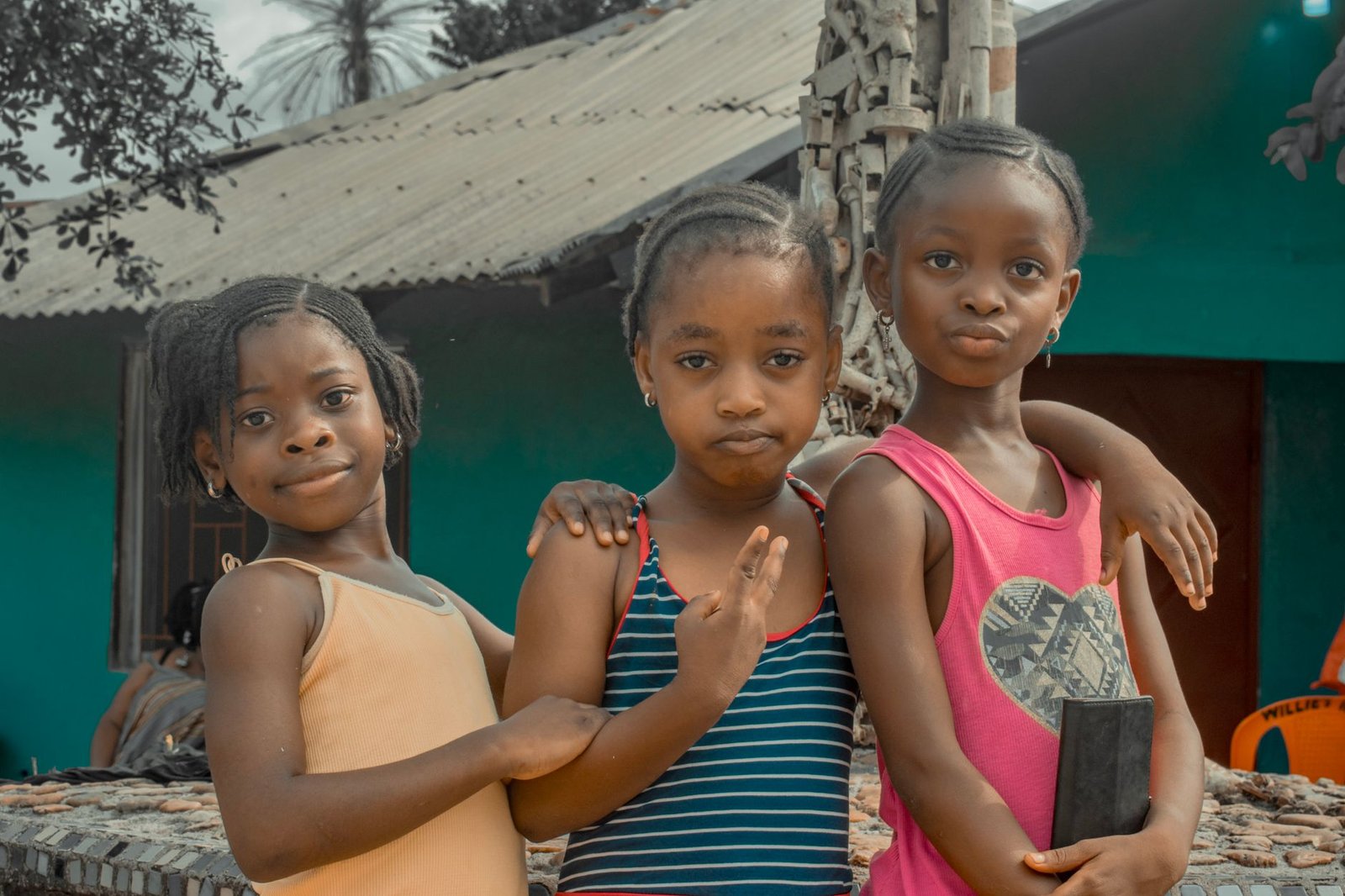 Safeguarding Children Certification (includes KCSIE updates) - A group of three smiling African children posing together outdoors in Liberia.