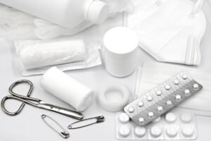 First Aid Appointed Person Certification - A flat lay of essential first aid supplies and medical equipment on a white background.