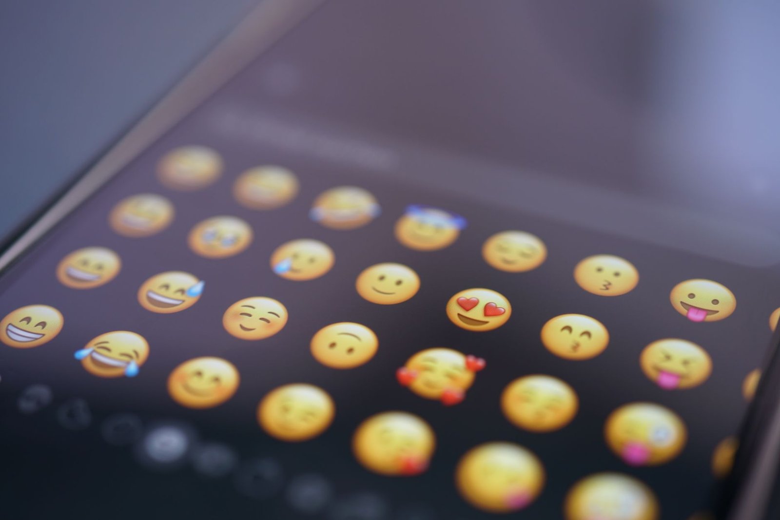 Cupcake Decorating – Emoji Pack - A close-up view of various emojis on a smartphone screen, symbolizing digital communication and social media use.