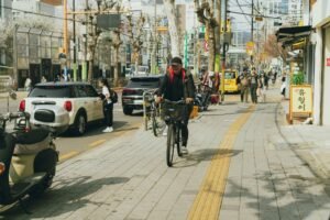 UTI Sepsis Certification - Bustling street scene in Seoul with people and cyclists on a sunny spring day.