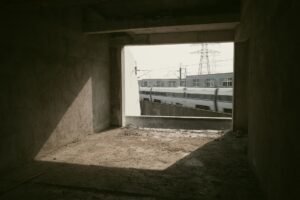 Speeding on Site Awareness Certification - A high-speed train rushes past an unfinished building interior, creating a contrast of motion and stillness.