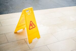Key Mistakes to Avoid When Marketing Certification - A bright yellow caution sign placed on a tile floor indicating a wet area for safety.