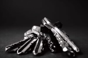 Key Tools and Knowledge for Team Leading Certification - A close-up shot of a pile of metallic keys on a dark surface, emphasizing security and precision.