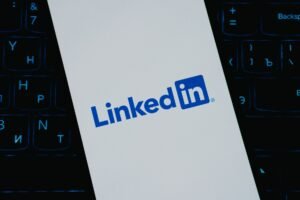 Reddit Marketing Certification - Close-up of LinkedIn logo on smartphone screen, with keyboard background.