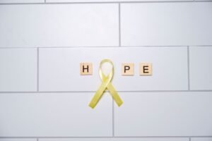 Mental Health Awareness Certification - A yellow ribbon forming the word 'hope' with tiles on a white tiled background, symbolizing awareness and support.