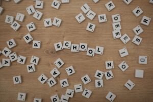Microsoft Word Certificate Level 3 - Scattered Scrabble tiles on wood with 'School' spelled out, ideal for educational themes.