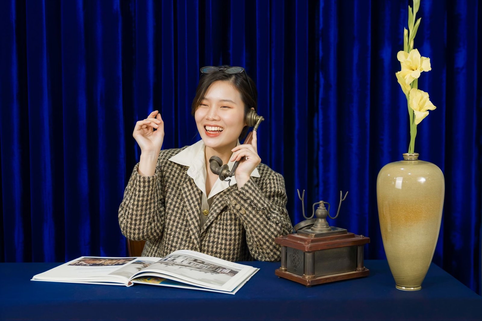 Learning Impressive Telephone Techniques Certification - Woman in retro attire smiling while using a vintage phone, with a decorative vase on a table.