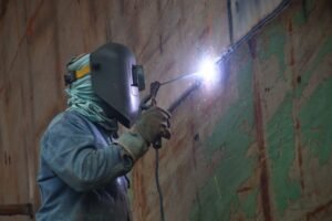 Lone Working Awareness Certification - A welder works in a Keraniganj shipyard, highlighting industrial labor's skilled techniques.