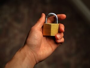 Deprivation of Liberty Safeguards Certification - Hand holding a brass padlock, symbolizing security and protection