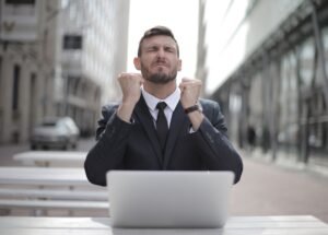 Finding Your Perfect Career For Success and Enjoyment Training - Confident businessman in Budapest celebrates success with a fist pump, reflecting a professional achievement.