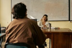Safeguarding for Teachers Certification - A teacher engages with a student in a university classroom setting, fostering learning.