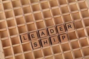 Motivation Skills Certification - Wooden letter blocks spelling 'LEADERSHIP' on a grid background, emphasizing the leadership concept.
