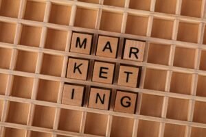 Advertising and Marketing Certification Level 2 - Wooden letter tiles spell out the word marketing on a grid background, showcasing creativity and business concept.
