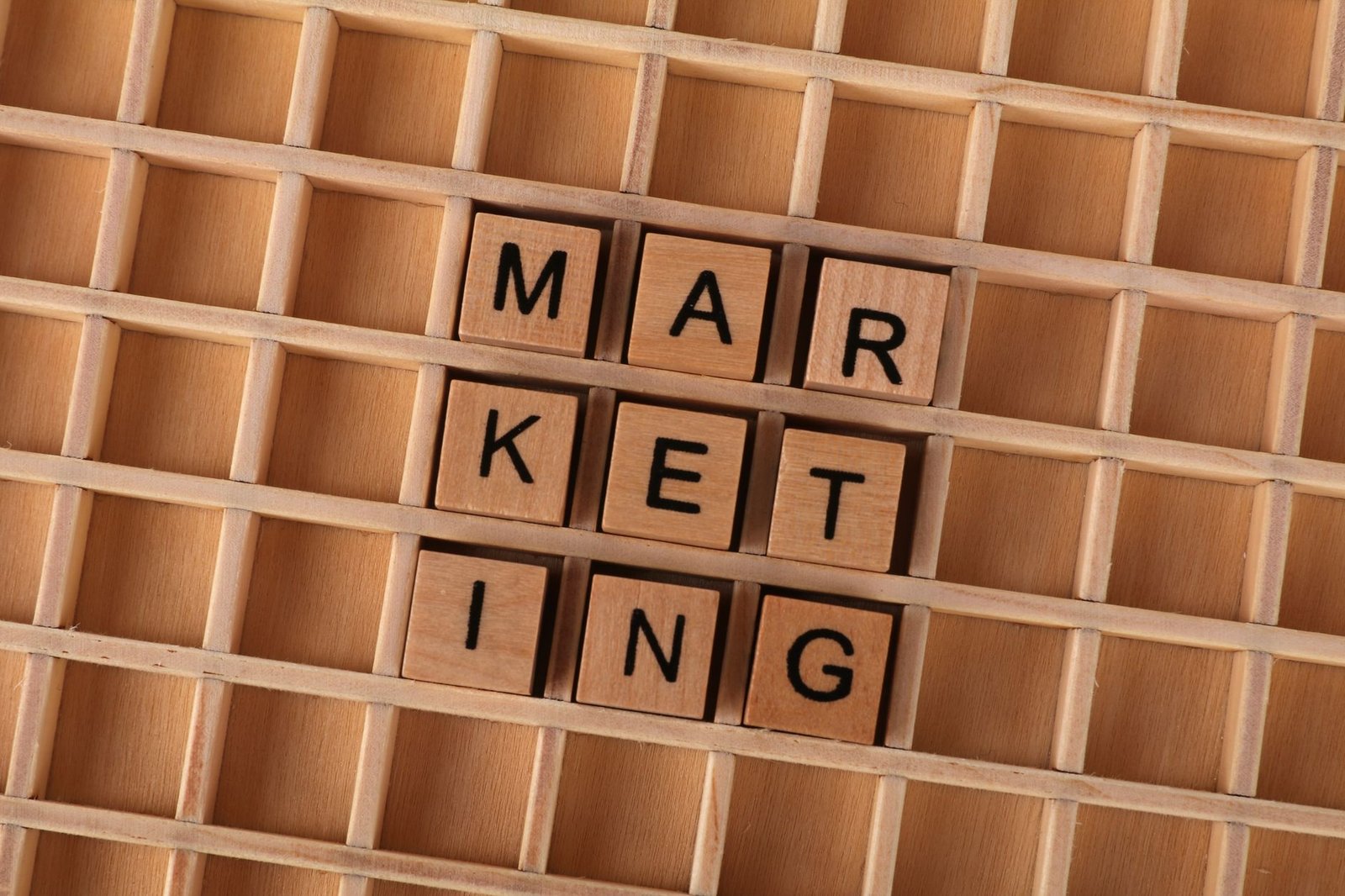 Advertising and Marketing Certification Level 2 - Wooden letter tiles spell out the word marketing on a grid background, showcasing creativity and business concept.