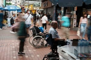 Privileged Access Users - Vibrant city street with wheelchair users and fast-moving shoppers, capturing urban life.
