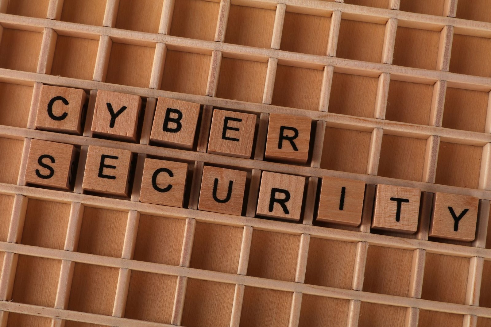 Perfect Passwords – Protecting Passwords - Wooden letter blocks spelling 'CYBER SECURITY' on a wooden grid background for data protection themes.