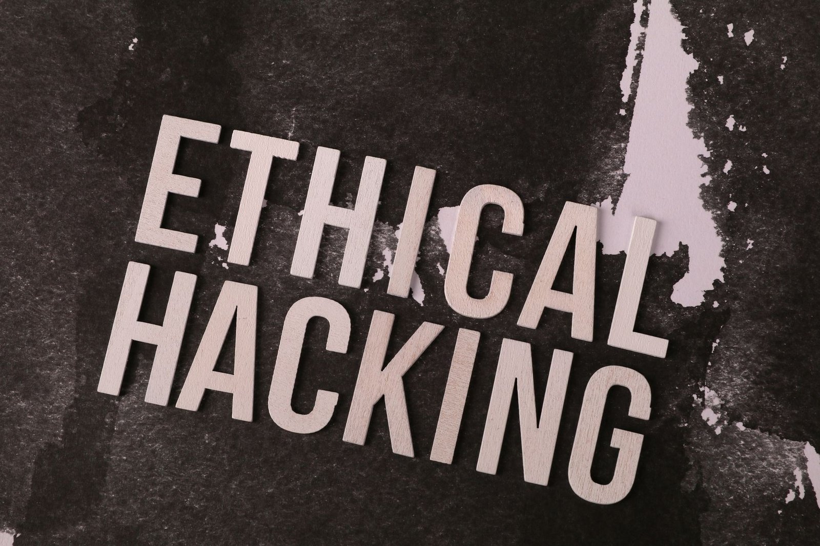 The Importance of Ethics Certification - Conceptual image showing the words 'Ethical Hacking' on a textured abstract background.
