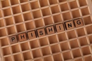 AI Phishing - Wooden Scrabble tiles arranged to spell 'Phishing', illustrating online security concepts.