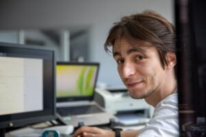 Excel Macros Certification - A young professional working at his desk in a contemporary office environment.