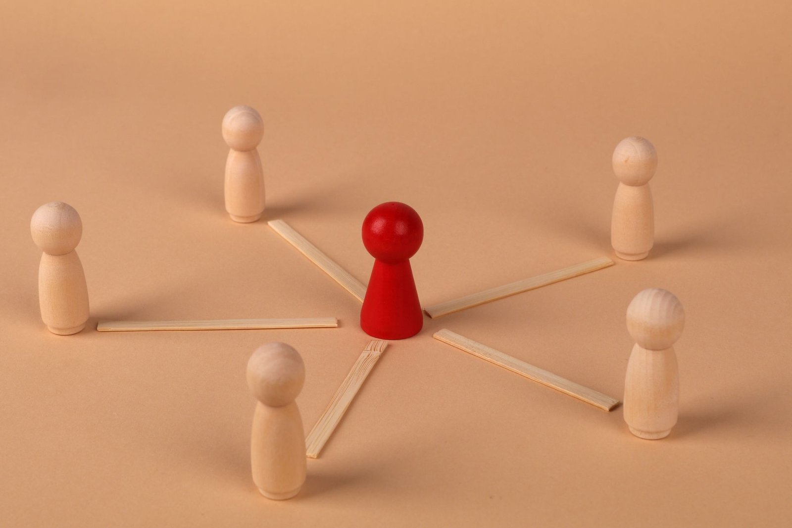 Delegation of Authority Certification - Wooden figures with red leader representing teamwork and influence.