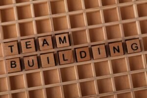 Communication Skills Certification - Scrabble letters spelling 'TEAM BUILDING' on a wooden board symbolize teamwork and collaboration.